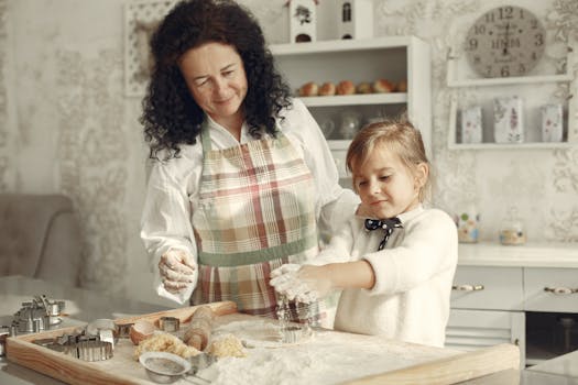 Une grand-mère et sa petite-fille préparent des sablés sur une table en bois, entourées d'ustensiles de pâtisserie.